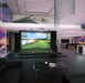 Golfzon Golf Simulator vooraanzicht in woonkamer met tafel, bank en piano erbij. De gehele golfsimulator staat hier in de woonkamer