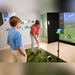 SkyTrak Indoor launch monitor vader en zoon die aan het golfen zijn op de golfsimulator
