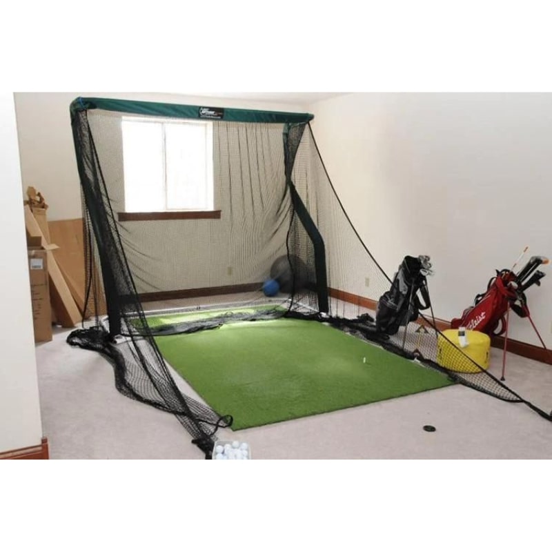 The Net Return Pro Turf Mat in de garage met golfclubs, golftassen en een net van The Net return. 